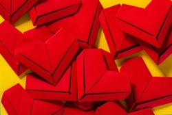 Red paper hearts on yellow background,the concept of love, the day of St. Valentine's Day,Red origami hearts on yellow background,