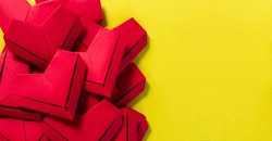 Paper hearts on a yellow background, the concept of love, the day of St. Valentine's Day,Red origami hearts on yellow background,