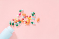 pills and pill bottles on pink background,Assorted pharmaceutical medicine pills, tablets and capsules and bottle on pink background. Top view. Flat lay. Copy space. Medicine concept. Heap of pills on