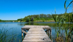 Long Old wooden pier and beautiful lake. Empty on small country lake. of summer. Place for text