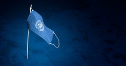 World Health Organization mask on dark blue background. Waving flag of WHO painted on medical mask on pole. Concept of The banner of the fight against the epidemic coronavirus COVID-19. Copy space