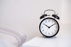 Black alarm clock on night stand, ten past ten oclock