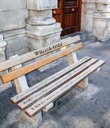 Whites only -  old bench with an inscription left as  memory of apartheid, racism and segregation.  White's only - the inscription on the bench left on the street of Cape Town. Africa
