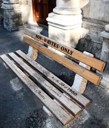 Non whites only -  old bench with an inscription left as  memory of apartheid, racism and segregation.  Non Whites; Only;    street;  Cape Town; Africa