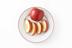 Red apples and apple slices on a white plate.
