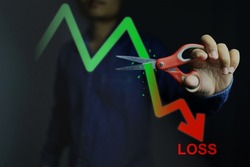 Investors decide to use scissors to cut or eliminate the loss portion of the red chart to maintain costs or prevent further losses in the stock market. cut loss concept.
