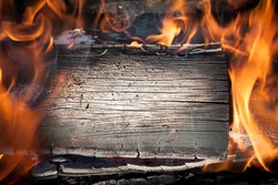 Burning black horizontal board with open red fire flame. Grey burned wooden board texture. Burnt wooden Board. Burned scratched hardwood surface. Smoking wood plank background.