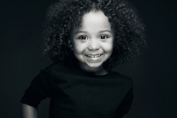 The natural beauty of a little girl under the effect of black and white and also the splendor of her color under the light of a studio decorated by her charm and her smile.
