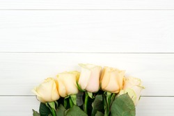 Bouquet of beige roses on white wooden vintage background, flat lay, top view, copy space. Mothers day. Valentines day.