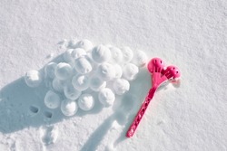 A children toy is a tool for modeling snowballs from snow. Red color plastic device. Winter outdoor kids games. Active leisure gift. Snowy background. Copy space. Banner. Ice forceps. New year time.