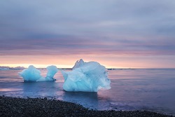 Ice floe in the water by the ocean at sunrise. glacial lagoon. Iceland. long exposure with blurry water.
