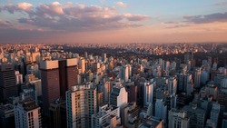 Aerial drone view of cityscape bathed in magic hour sunset light. Skyscrapers of landmark Avenida Paulista in major metropolitan city of Sao Paulo, Brazil.