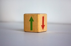Conceptual image of choice and direction. Wooden cube with arrows pointing in opposite directions. Beautiful white background, copy space.