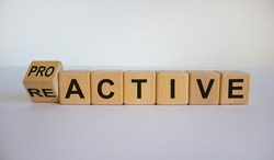 Turned a cube and changed the word reactive to proactive. Business concept. Beautiful white background, copy space.