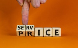 Service price symbol. Hand turns a cube and changes the words 'service' to 'price'. Beautiful orange background. Business and service price concept. Copy space.