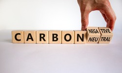 From carbon neutral to negative. Hand flips cubes and changes words 'carbon neutral' to 'carbon negative'. Beautiful white background, copy space. Business, ecological and carbon negative concept.