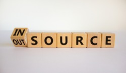 Outsource or insource symbol. Fliped wooden cubes and changed the word 'outsource' to 'insource'. Beautiful white background, copy space. Business and outsource or insource concept.