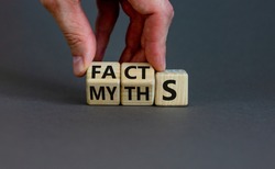 Facts or myths symbol. Businessman hand turns cubes and changes the word 'myths' to 'facts'. Beautiful grey background, copy space. Business and facts or myths concept.