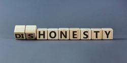 Honesty or dishonesty symbol. Turned cube and changed the word 'dishonesty' to 'honesty'. Beautiful grey background. Business and honesty or dishonesty concept. Copy space.