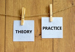 Theory and practice symbol. Wooden clothespins with white sheets of paper. Words 'theory practice'. Beautiful wooden background. Business, theory and practice concept, copy space.