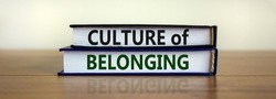 Culture of belonging symbol. Books with words 'culture of belonging' on beautiful wooden table, white background. Business, culture of belonging concept. Copy space.