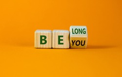 Be you, belong symbol. Turned a cube and changed words 'be you' to 'belong'. Beautiful orange background. Business, belonging and be you belong concept. Copy space.