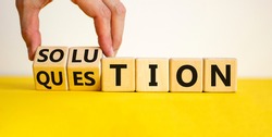 Question and solution symbol. Businessman turns wooden cubes and changes the word 'question' to 'solution'. Beautiful yellow table, white background, copy space. Business question and solution concept