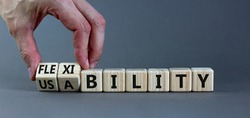 Flexibility and usability symbol. Businessman turns wooden cubes and changes words 'usability' to 'flexibility'. Beautiful grey background, copy space. Business, flexibility and usability concept.