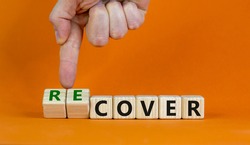 Time to recover symbol. Businessman turns wooden cubes and changes the word 'cover' to 'recover'. Beautiful orange background. Business, cover or recover concept. Copy space.