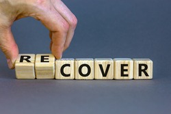 Time to recover symbol. Businessman turns wooden cubes and changes the word 'cover' to 'recover'. Beautiful grey background. Business, cover or recover concept. Copy space.