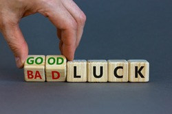 Good or bad luck symbol. Businessman turns wooden cubes and changes words 'bad luck' to 'good luck'. Beautiful grey background, copy space. Business and good or bad luck concept.