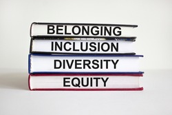 Belonging symbol. Books with words 'belonging, inclusion, diversity equity' on beautiful white table, white background. Business, belonging, diversity and inclusion concept. Copy space.
