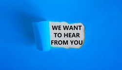 Support symbol. Concept words 'we want to hear from you' appearing behind torn blue paper. Beautiful blue background. Business and support concept.