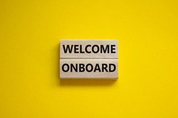 Welcome onboard symbol. Wooden blocks with words 'Welcome onboard' on beautiful yellow background. Business and welcome onboard concept. Copy space.