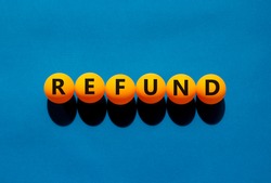 Refund and bonus symbol. The concept word 'refund' on orange table tennis balls on a beautiful blue background. Business and refund concept.