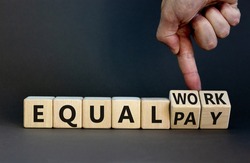 Equal pay and work symbol. Businessman turns wooden cubes and changes words equal pay to equal work. Beautiful grey background. Copy space. Business and equal pay and work concept.