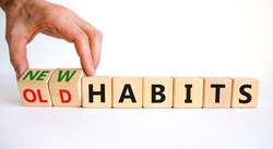 New or old habits symbol. Businessman turns wooden cubes and changes words 'old habits' to 'new habits'. Beautiful white table, white background. Business, old or new habits concept. Copy space.