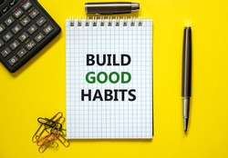 Build good habits symbol. Words 'Build good habits' on white note. Yellow background, paper clips, metallic pen and calculator. Business, psychology and build good habits concept. Copy space.
