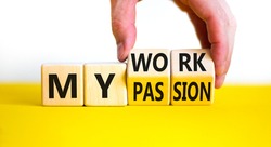 My work or passion symbol. Businessman turns wooden cubes and changes words 'My work' to 'My passion'. Beautiful yellow table, white background, copy space. Business and my work or passion concept.