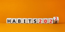 2022 habits and new year symbol. Turned a wooden cube and changed words 'habits 2021' to 'habits 2022'. Beautiful orange background, copy space. Business, 2022 habits and new year concept.