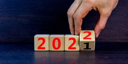 2022 happy new year symbol. Businessman turns a cube, symbolize the change from 2021 to the new year 2022. Beautiful black background. Copy space. Business and 2022 happy new year concept.