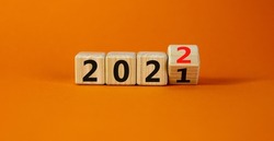 2022 happy new year symbol. Turned a cube, symbolize the change from 2021 to the new year 2022. Beautiful orange background. Copy space. Business and 2022 happy new year concept.