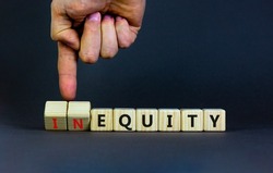 Inequity or equity symbol. Businessman turns wooden cubes and changes the word inequity to equity. Business and inequity or equity concept. Beautiful grey background, copy space.