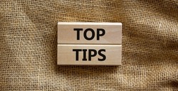 Top tips symbol. Concept words Top tips on wooden blocks on a beautiful canvas background. Business and Top tips concept, copy space.