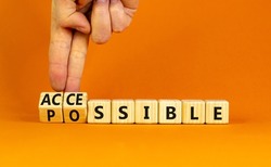 Possible and accessible symbol. Businessman turns wooden cubes and changes the word possible to accessible. Business and possible or accessible concept. Beautiful orange background, copy space.