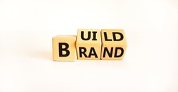 Build your brand symbol. Turned wooden cubes and changes the word 'build' to 'brand'. Beautiful white background. Build your brand and business concept. Copy space.