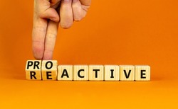 Reactive or proactive symbol. Businessman turns wooden cubes and changes the word reactive to proactive. Business and reactive or proactive concept. Beautiful orange background, copy space.