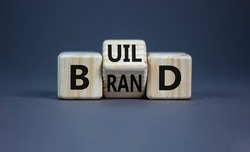 Build your brand symbol. Turned wooden cubes and changed the word 'build' to 'brand'. Beautiful grey background. Build your brand and business concept. Copy space.