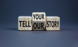 Tell our or your story. Turned wooden cubes and changed words tell our story to tell your story. Beautiful grey background, copy space. Business, storytelling and our or your story concept.