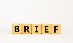 Brief symbol. The concept word 'brief' on wooden cubes on a beautiful white table, white background. Business and brief concept. Copy space.